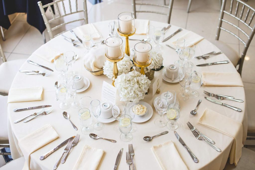 Event table with ivory tablecloth and gold candles