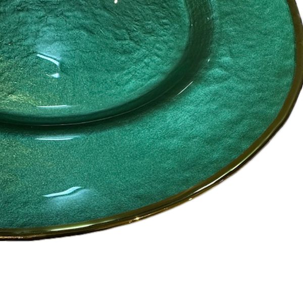 Close up of a green glass charger plate with gold rim